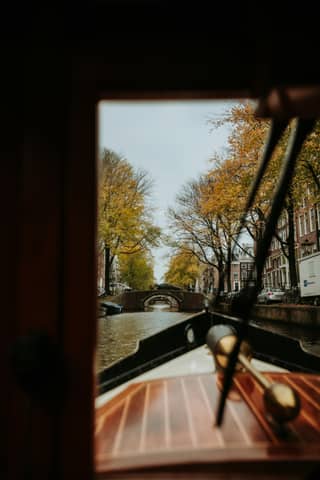 View of a canal and cityscape from a boat.