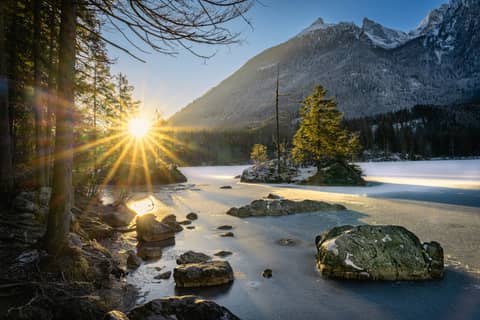 Sunrise illuminates a beautiful lake and snowy mountains.
